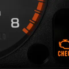 Pomarańczowy symbol "CHECK ENGINE" świeci się, sygnalizując migający check engine i nierówną pracę silnika. Obok widać fragment obrotomierza.