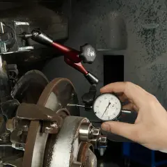 Mechanik mierzy bicie tarczy hamulcowej, aby zapobiec drganiom przy hamowaniu z dużej prędkości.