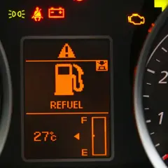Na desce rozdzielczej świeci się kontrolka paliwa z napisem "REFUEL". Wskazuje to, że zostało mało paliwa i warto sprawdzić, ile można przejechać na rezerwie.