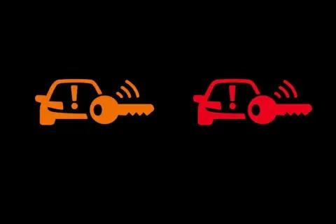 Pomarańczowa i czerwona kontrolka samochodu z kluczem Opel. Sygnalizuje problem z immobilizerem lub kluczykiem.