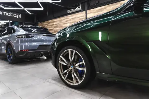 Dwa lśniące SUV-y, jeden zielony, drugi szary, stoją w garażu. Detailing co to? To dbałość o każdy szczegół tych pięknych aut.