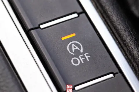Przycisk systemu start-stop w samochodzie z napisem "A OFF" i pomarańczową kontrolką.
