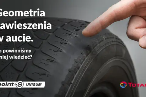 Palec wskazuje na zużyty bieżnik opony, sugerując problemy z geometrią zawieszenia w aucie.