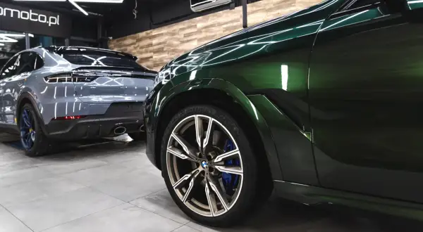 Dwa lśniące SUV-y, jeden zielony, drugi szary, stoją w garażu. Detailing co to? To dbałość o każdy szczegół tych pięknych aut.
