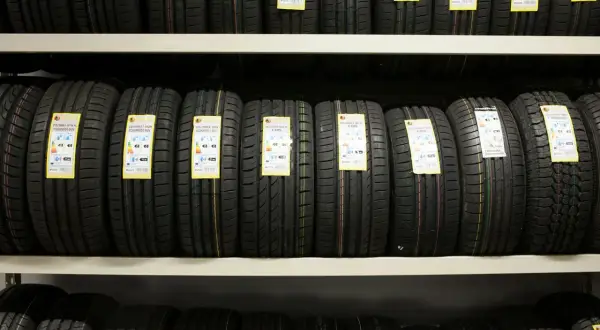 Na półkach sklepowych rzędy nowych opon, każda z etykietą informującą o parametrach. Jaka opona będzie najlepsza?