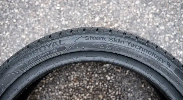 Opona Uniroyal z technologią Shark Skin, idealna na deszczowe dni, leży na zewnątrz na mokrym asfalcie.