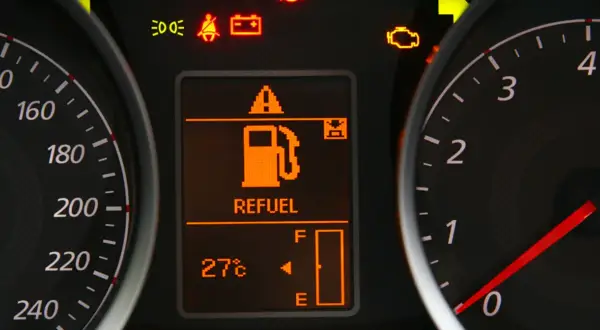 Na desce rozdzielczej świeci się kontrolka paliwa z napisem "REFUEL". Wskazuje to, że zostało mało paliwa i warto sprawdzić, ile można przejechać na rezerwie.