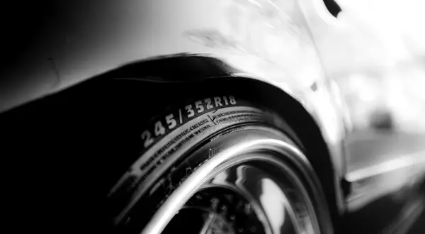 Zbliżenie na oponę samochodową z oznaczeniem 245/35R18 i błyszczącą felgę.