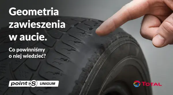 Palec wskazuje na zużyty bieżnik opony, sugerując problemy z geometrią zawieszenia w aucie.