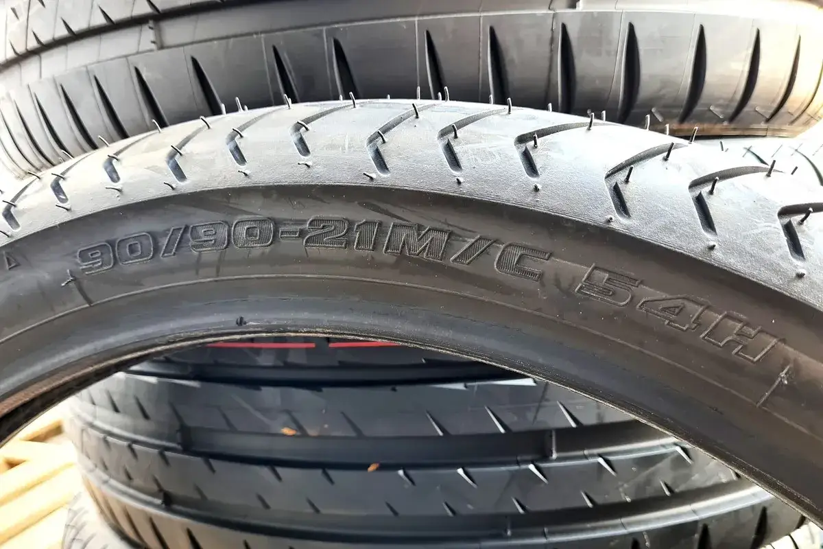 Opona motocyklowa z oznaczeniem 90/90-21. Dowiedz się, jak obliczyć wysokość opony, analizując jej rozmiar.
