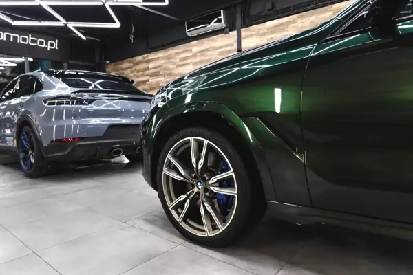 Dwa lśniące SUV-y, jeden zielony, drugi szary, stoją w garażu. Detailing co to? To dbałość o każdy szczegół tych pięknych aut.