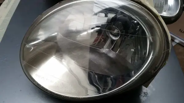 Efekt przed i po: jak wyczyścić lampy w samochodzie. Jedna połowa klosza jest matowa, druga lśni czystością.