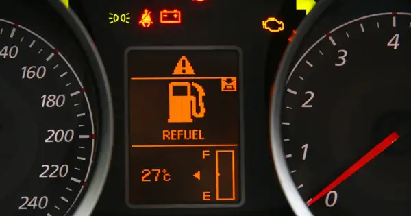 Na desce rozdzielczej świeci się kontrolka paliwa z napisem "REFUEL". Wskazuje to, że zostało mało paliwa i warto sprawdzić, ile można przejechać na rezerwie.