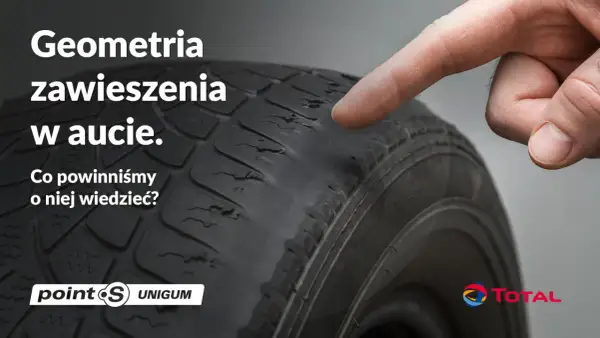 Palec wskazuje na zużyty bieżnik opony, sugerując problemy z geometrią zawieszenia w aucie.